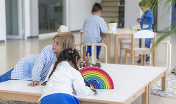 Interior de aula donde se ven niños jugando