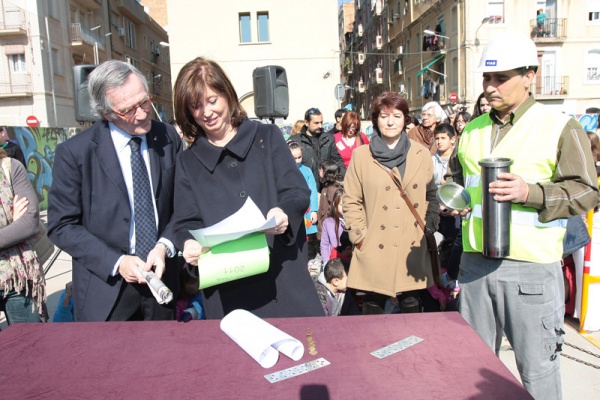 El alcalde, Xavier Trias, y la consejera de Enseñanza, Irene Rigau colocan objetos de recuerdo para la primera piedra